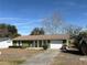 Ranch style home with a green exterior, attached garage, and landscaping at 15083 Sw 43Rd Terrace Rd, Ocala, FL 34473