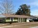Green house with white trim, brown roof, and a two-car garage at 15083 Sw 43Rd Terrace Rd, Ocala, FL 34473