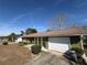 Green house with white garage door and mature trees in the yard at 15083 Sw 43Rd Terrace Rd, Ocala, FL 34473