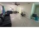 Living room features a large tiled floor and black leather sofas at 15083 Sw 43Rd Terrace Rd, Ocala, FL 34473