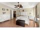 Main bedroom with a ceiling fan, white dresser and a king-size bed at 15391 Se 90Th Ct, Summerfield, FL 34491