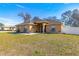 Tan one-story house with a brown door and nicely landscaped yard at 15391 Se 90Th Ct, Summerfield, FL 34491