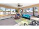 Relaxing screened porch with seating and a ceiling fan at 15391 Se 90Th Ct, Summerfield, FL 34491