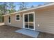 Exterior of tan house with a sliding glass door and small patio in the backyard at 15982 Sw 30 Ln, Ocala, FL 34481