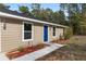 Charming single-story home showcasing a blue front door and neatly landscaped front yard at 15982 Sw 30 Ln, Ocala, FL 34481