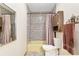 A bright bathroom showcases mosaic tile walls, a storage cabinet, and a tub with a curtain at 2145 Ne 45Th Ave # 2145, Ocala, FL 34470