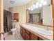Bright bathroom featuring double sink, vanity with storage, framed mirrors, and tiled shower at 2145 Ne 45Th Ave # 2145, Ocala, FL 34470