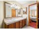 Bathroom vanity featuring double sinks, wood cabinets, and a view into the bedroom at 2145 Ne 45Th Ave # 2145, Ocala, FL 34470