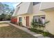 Inviting townhouse entrance with a red door, a red privacy fence, and well-maintained landscaping at 2145 Ne 45Th Ave # 2145, Ocala, FL 34470