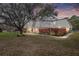 Charming townhouse with a well-maintained lawn, mature tree, and a red privacy fence at sunset at 2145 Ne 45Th Ave # 2145, Ocala, FL 34470