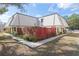 Charming townhouse with a well-maintained lawn, mature landscaping, and a red privacy fence at 2145 Ne 45Th Ave # 2145, Ocala, FL 34470