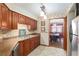 Traditional-style kitchen featuring warm wood cabinetry, tile backsplash, and stainless steel appliances with dining room view at 2145 Ne 45Th Ave # 2145, Ocala, FL 34470