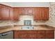 Traditional-style kitchen featuring warm wood cabinetry, tile backsplash, and stainless steel appliances at 2145 Ne 45Th Ave # 2145, Ocala, FL 34470