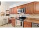 Traditional-style kitchen featuring warm wood cabinetry, tile backsplash, and stainless steel appliances at 2145 Ne 45Th Ave # 2145, Ocala, FL 34470