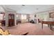 Expansive living room featuring a piano, built-in shelving, and a seamless flow to an enclosed sunroom at 2145 Ne 45Th Ave # 2145, Ocala, FL 34470