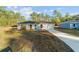 New single story home with gray siding and a teal front door at 24025 Nw Foxglove Lane, Dunnellon, FL 34431