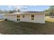 House exterior showcasing a light gray siding and a grassy backyard at 24025 Nw Foxglove Lane, Dunnellon, FL 34431