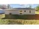 Rear view of a house with a sliding glass door and a small yard at 24025 Nw Foxglove Lane, Dunnellon, FL 34431