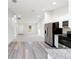 Open concept kitchen, stainless steel appliances, and wood-look floors at 24025 Nw Foxglove Lane, Dunnellon, FL 34431