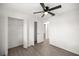 Bright bedroom with ceiling fan, wood-look floors, and an en-suite closet and bathroom at 26 Spring Cir, Ocala, FL 34472