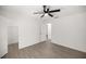 Bright bedroom with ceiling fan, wood-look floors, and an en-suite closet and bathroom at 26 Spring Cir, Ocala, FL 34472