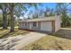 View of the renovated single-story home with a new driveway and landscaping at 26 Spring Cir, Ocala, FL 34472