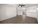 Open-concept living room with modern flooring and a ceiling fan, seamlessly flowing into the adjacent kitchen at 26 Spring Cir, Ocala, FL 34472