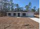 Newly constructed home with a gray exterior and a driveway at 316 Nw Narcissus Rd, Dunnellon, FL 34431