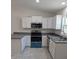 Modern kitchen with white cabinets, stainless steel appliances, and dark countertops at 316 Nw Narcissus Rd, Dunnellon, FL 34431