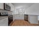 Modern kitchen with stainless steel appliances, white cabinets, granite countertops, and wood flooring at 3212 Ne 46Th Ave, Ocala, FL 34470