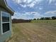 Spacious backyard featuring a green lawn and partial fence at 6414 Sw 67Th Pl, Ocala, FL 34476