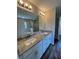 Modern bathroom with double sinks, granite countertop, and a large mirror at 6414 Sw 67Th Pl, Ocala, FL 34476