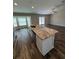 Open-concept kitchen with stainless steel appliances, granite countertops, and a large island at 6414 Sw 67Th Pl, Ocala, FL 34476