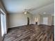 Spacious living room with dark vinyl wood flooring, a ceiling fan, and an open layout to other areas at 6414 Sw 67Th Pl, Ocala, FL 34476