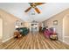 Spacious living room featuring wood flooring, ceiling fans, and sliding glass doors to the lanai at 6426 Sw 60Th Ct, Ocala, FL 34474