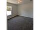 Spacious bedroom with gray carpeting and a large window at 67 Nw Sparrow Rd, Dunnellon, FL 34431