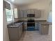 L-shaped kitchen with gray cabinets and a breakfast bar at 67 Nw Sparrow Rd, Dunnellon, FL 34431