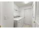 Well-lit laundry room with a washer, dryer, and storage shelves at 9014 Sw 96Th Ter, Ocala, FL 34481