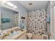 Bright bathroom with a light blue color scheme, vanity with a mirror, and a shower with a seashell-themed curtain at 9708 Sw 97Th St, Ocala, FL 34481