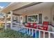 Inviting covered front porch featuring chairs, throw pillows, and decorative rug at 9708 Sw 97Th St, Ocala, FL 34481