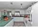 Bright kitchen with white cabinetry, green countertops, and a view into the adjacent dining area at 9708 Sw 97Th St, Ocala, FL 34481
