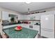 Well-lit kitchen featuring white cabinets, green countertops, and modern appliances at 9708 Sw 97Th St, Ocala, FL 34481