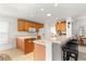 Kitchen with a breakfast bar, wood cabinets, and a view into the living area at 12595 Se 97Th Terrace Rd, Summerfield, FL 34491