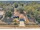 Aerial view of the house with a brown roof, long driveway, and trees surrounding the property at 13370 Sw 112Th Pl, Dunnellon, FL 34432