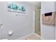 Bright bathroom featuring a glass shower door, tile flooring and walls, and decorative desert painting at 13370 Sw 112Th Pl, Dunnellon, FL 34432