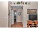 Hallway view with hardwood floors, neutral walls, decor shelf, and doorways leading into other rooms at 13370 Sw 112Th Pl, Dunnellon, FL 34432