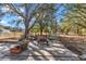 Backyard patio area with mature trees providing shade and a green bench at 13370 Sw 112Th Pl, Dunnellon, FL 34432