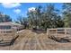 Gated yard with mature trees and partial view of the home and shed at 13370 Sw 112Th Pl, Dunnellon, FL 34432