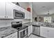 Close-up of kitchen with granite countertops, stainless steel appliances, and decorative backsplash at 13661 Sw 43Rd Cir, Ocala, FL 34473