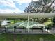 Bocce ball court featuring a shaded structure with benches, near a scenic lake at 1517 New Abbey Ave, Leesburg, FL 34788